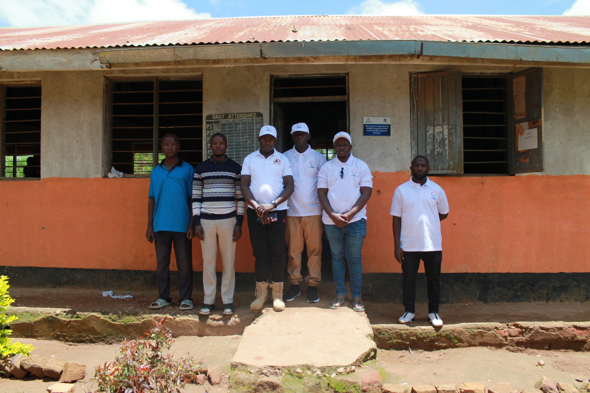 SODO team standing in front of a rural Ugandan primary school